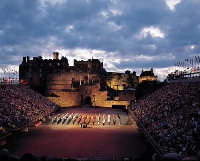 Performers in traditional military dress at the Royal Edinburgh Military Tattoo, set against the illuminated Edinburgh Castle at night