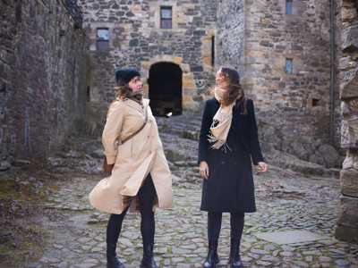Two young women exploring the stone-covered courtyard of Blackness Castle