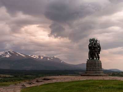 Dramatic Commando Memorial stone statue with views of Ben Nevis int he Background on cloudy day