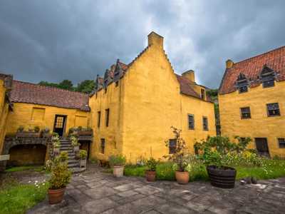 Quaint yellow building with garden patio in Culross village