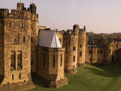 Exterior of Alnwick Castle with majestic stone walls resembling school of Hogwarts from Harry Potter