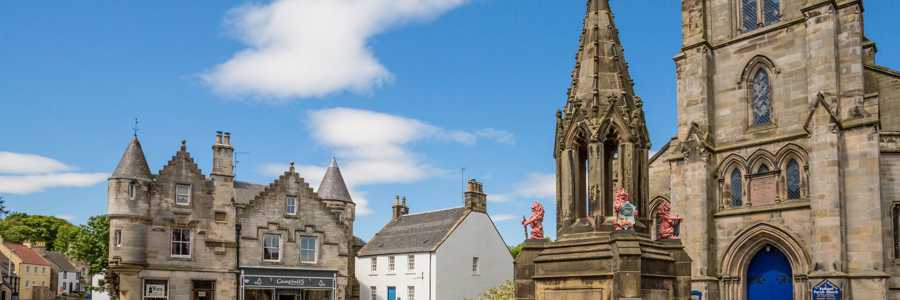 Falkland on a bright clear day with stone building and the iconic Bruce Fountain in the centre