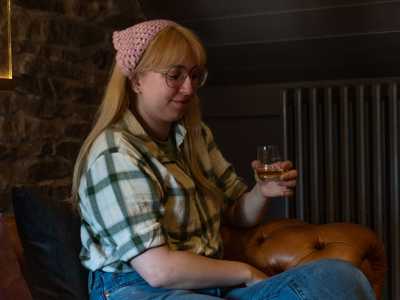 A woman laughing while sampling whisky during a whisky experience