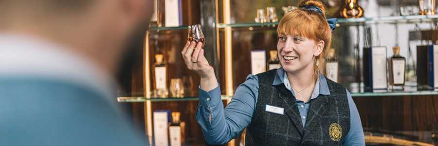 Young woman holding a whisky glass at Glenturret Whisky DIstillery