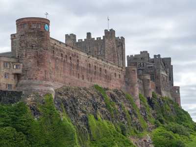 Exterior view of Bamburgh Castle's impressive stone walls sitting atop a rock