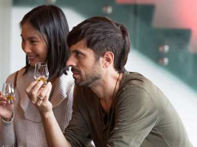 Young couple tasting whisky at a Highland Whisky Distillery in Scotland
