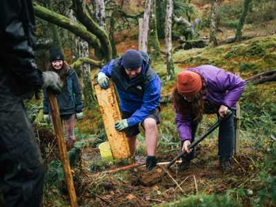 Man and woman steps in a forested area of Tormore Forest
