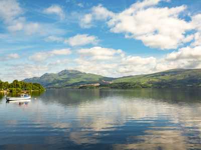 Shores of Loch Lomond with serene view of boats and hills