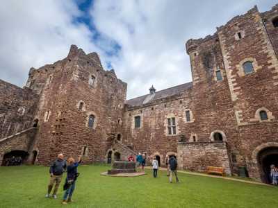 Grassy courtyard of Doune Castle surrounded by towering stone walls