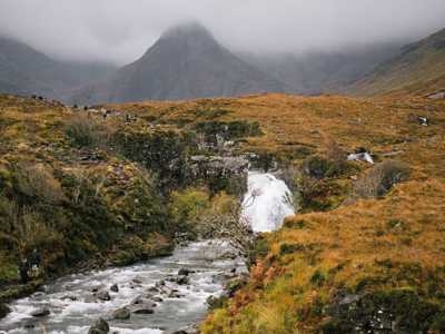 Fairy Pools in mist with crystal-clear water and surrounding rugged landscape on a foggy day
