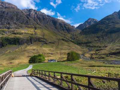 Bridge at Glen Coe on a clear sunny day and dramatic hills against blue sky