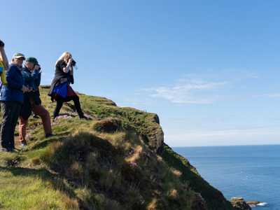 Group of travellers looking for sea and bird life by the cliffs at Troup head Nature Reserve