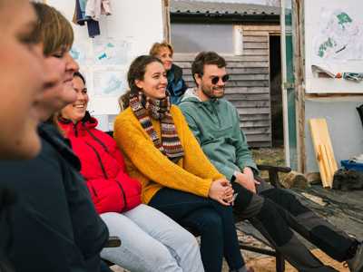 Group of volunteers inside a tent, gathered together in a natural setting